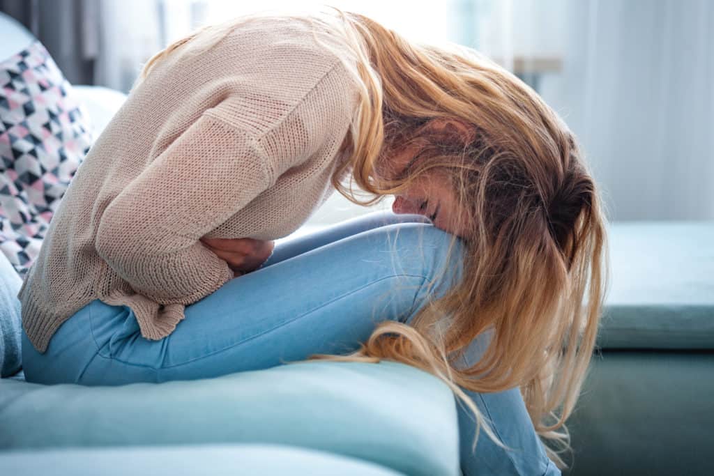woman keeled over with pelvic pain
