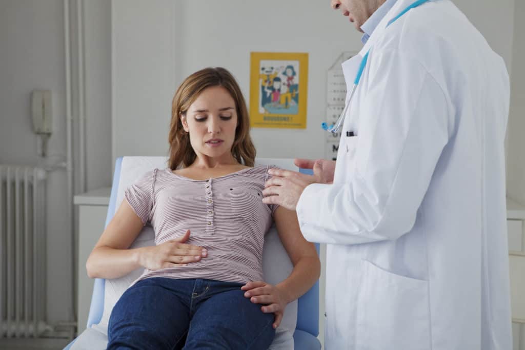 doctor looking at woman with abdominal pain