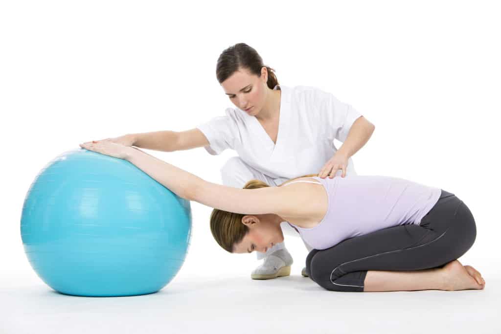 Woman receiving physical therapy with exercise ball